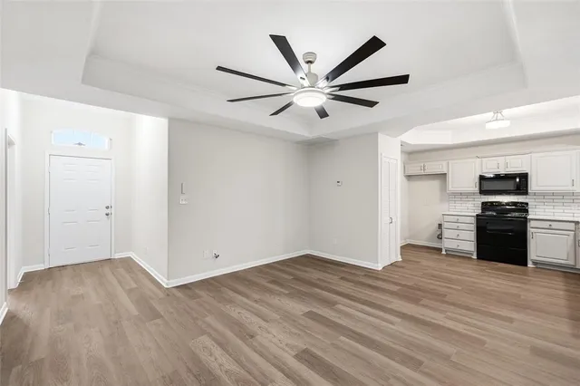 a view of a kitchen with wooden floor and a ceiling fan