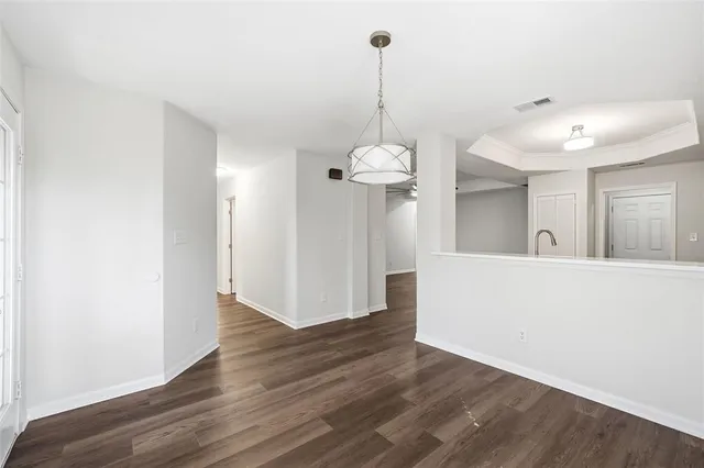 a view of a room with wooden floor and a chandelier