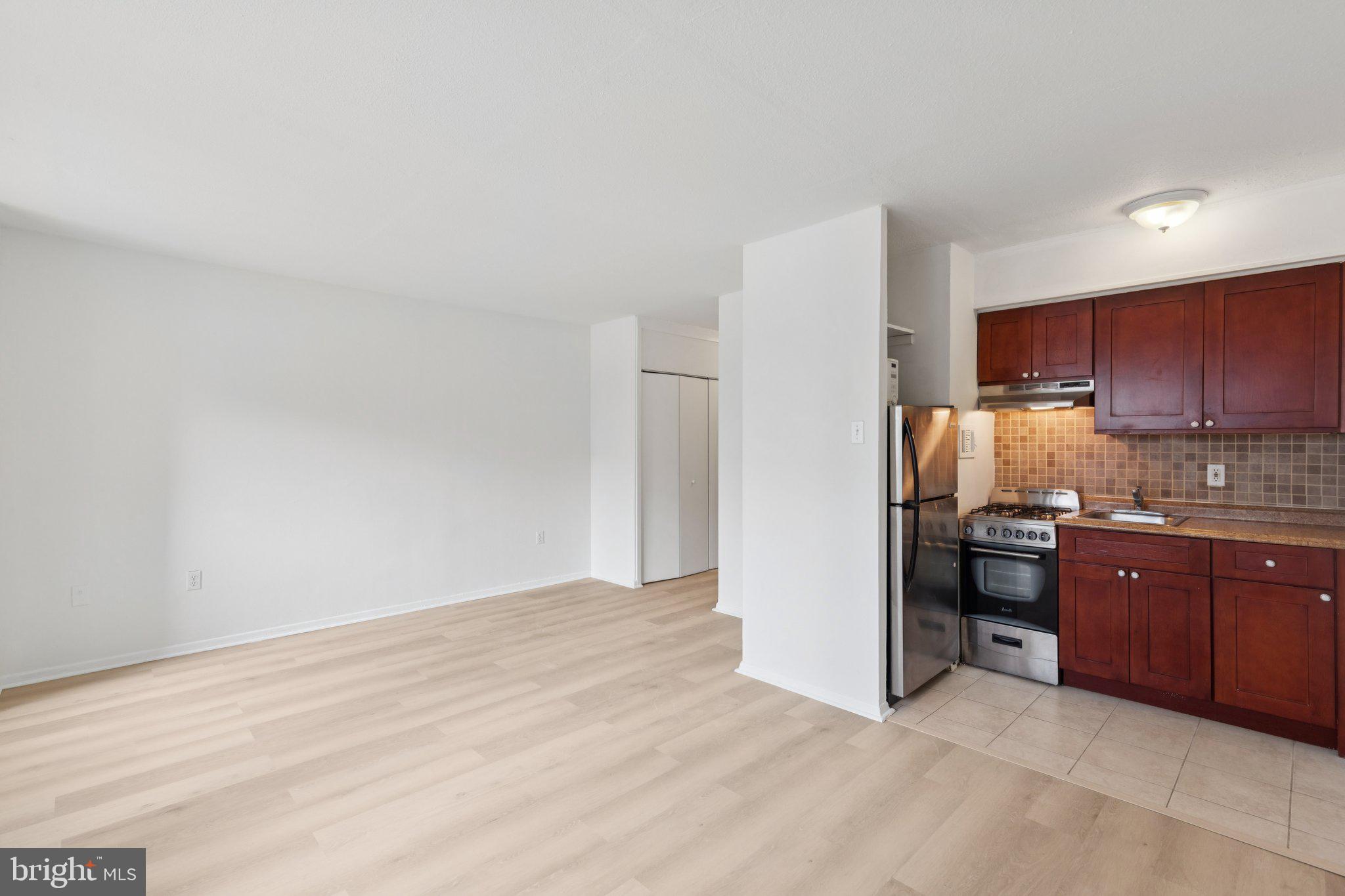 2101 Chestnut Street, Unit 324R Philadelphia, PA 19103 - Photo 6 of 21 a kitchen with kitchen island granite countertop wooden cabinets and stainless steel appliances