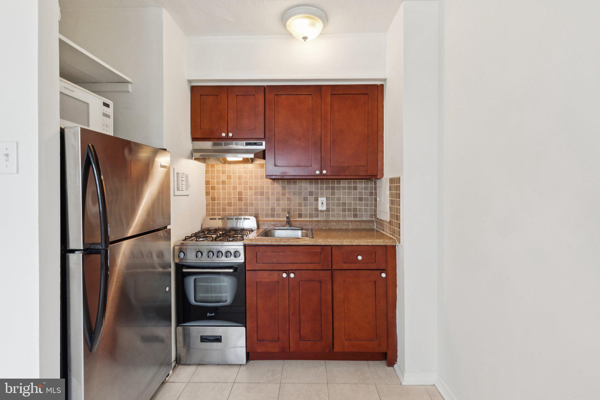 2101 Chestnut Street, Unit 324R Philadelphia, PA 19103 - Photo 7 of 21 a kitchen with stainless steel appliances granite countertop a refrigerator and a stove