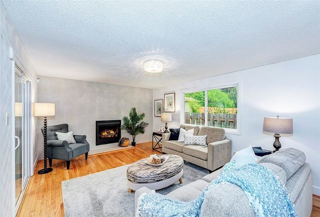 a living room with furniture fireplace and a large window