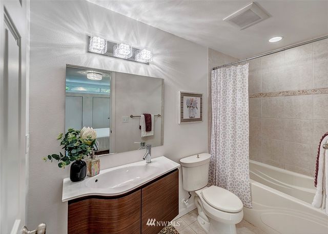 a bathroom with a sink toilet mirror and shower