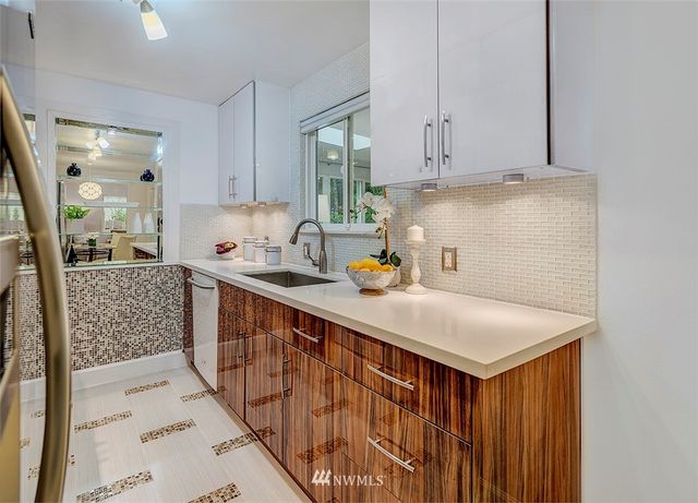 a kitchen with stainless steel appliances a sink cabinets and wooden floor