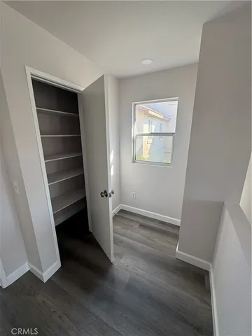 an empty room with wooden floor and window