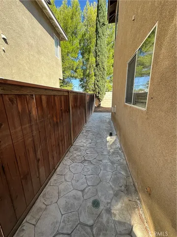 a view of a pathway of a house with wooden fence