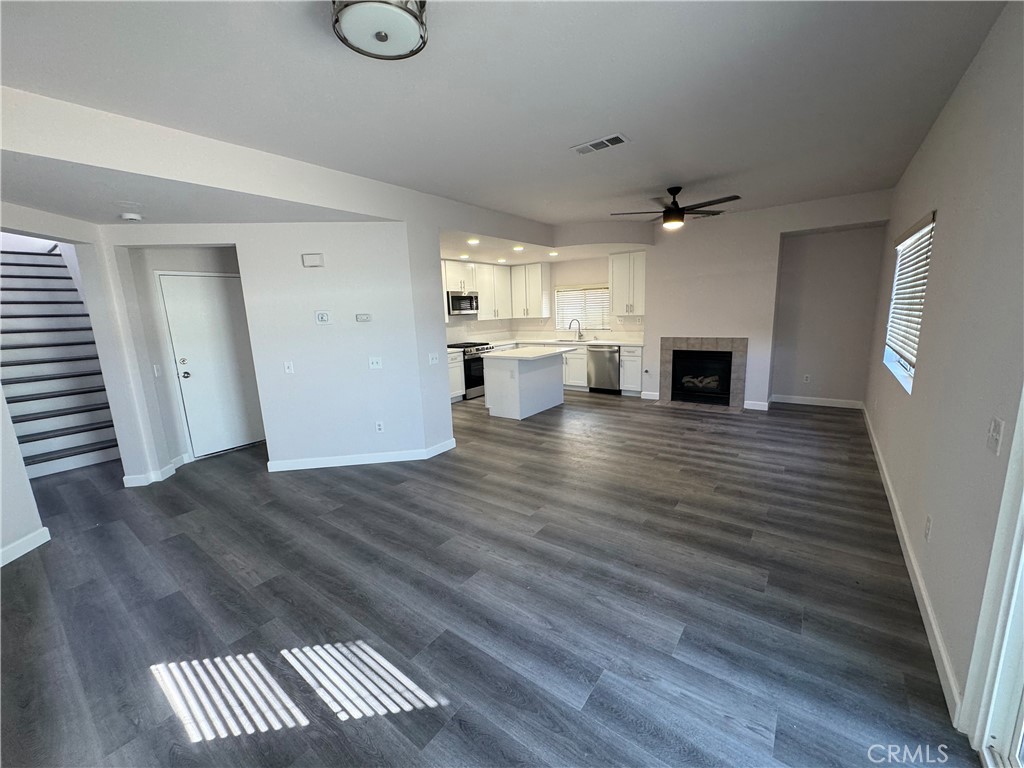 39790-39790 Monarch Drive Murrieta, CA 92563 - Photo 7 of 22 a view of kitchen and empty room with wooden floor