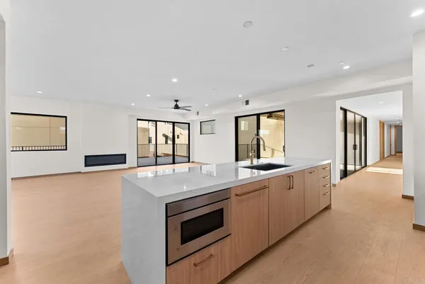 a large kitchen with stainless steel appliances granite countertop a stove a sink and a refrigerator with wooden floors