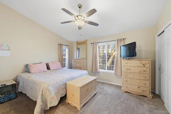 a spacious bedroom with a bed and a flat screen tv