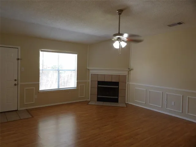 a view of empty room with wooden floor and fireplace