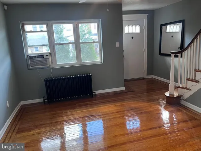 a view of a room with wooden floor air conditioner and windows
