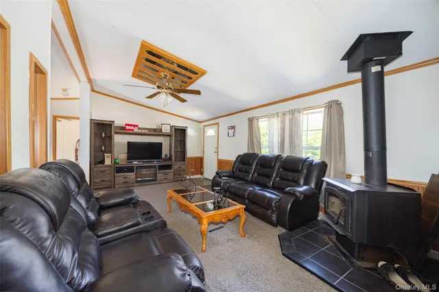 a living room with furniture a flat screen tv and a window