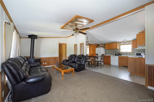 a living room with furniture a ceiling fan and a window