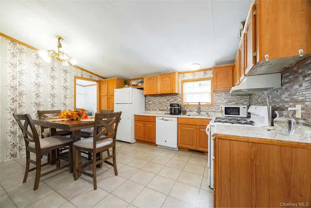 a kitchen with a stove a sink a dining table and chairs