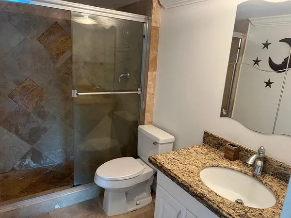 a bathroom with a granite countertop toilet sink and shower