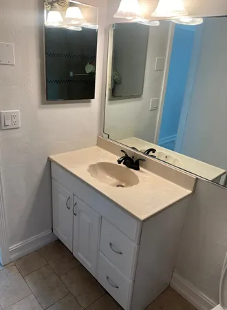 a bathroom with a sink vanity and mirror