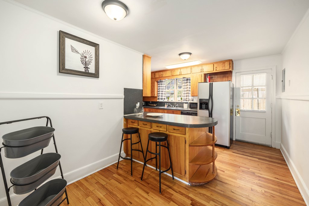 1620 Springer Street Columbus, GA 31901 - Photo 21 of 41 a kitchen with stainless steel appliances granite countertop a stove a refrigerator a sink a dining table and chairs with wooden floor