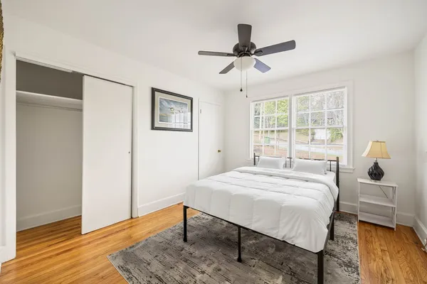 a bedroom with a bed and wooden floor