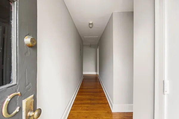 a view of a hallway with wooden floor