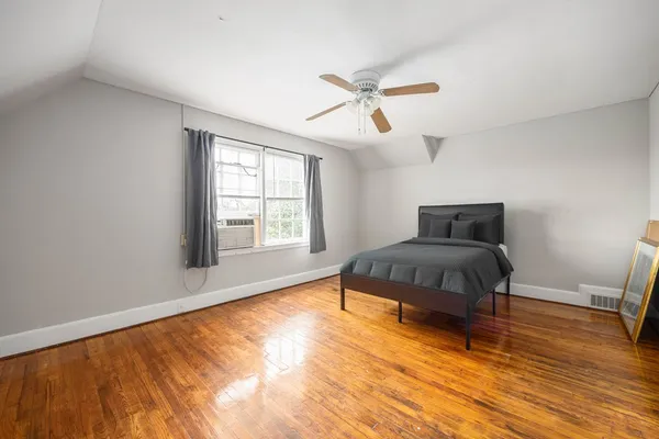 a bedroom with a bed and wooden floor