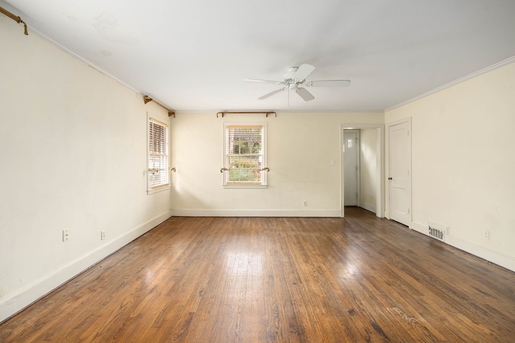 1620 Springer Street Columbus, GA 31901 - Photo 10 of 41 an empty room with wooden floor chandelier fan and windows