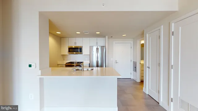 a view of a kitchen with a refrigerator and a sink