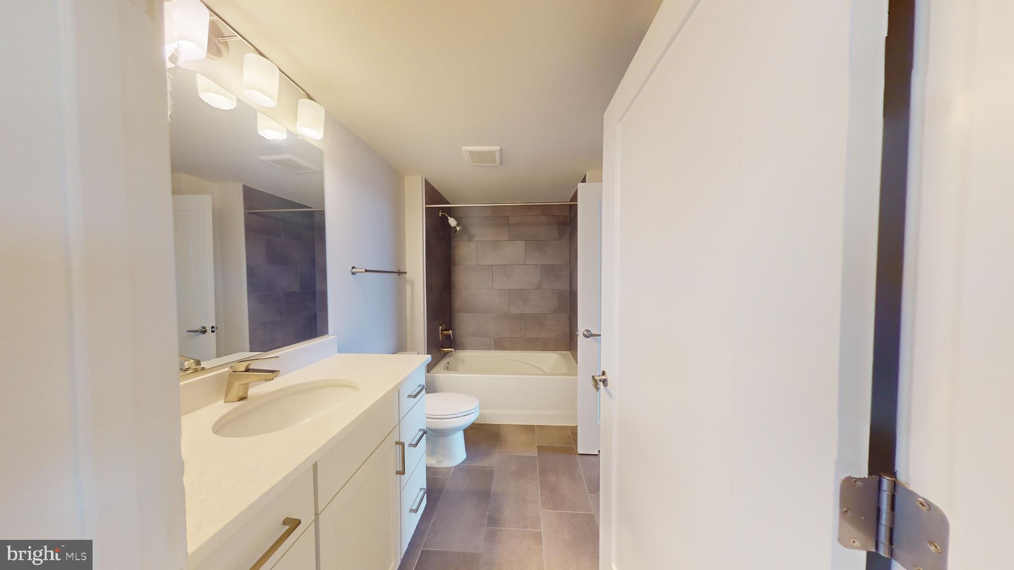 50 Florida Avenue Northeast, Unit 823 Washington, DC 20002 - Photo 10 of 12 a bathroom with a granite countertop sink a toilet a mirror and shower