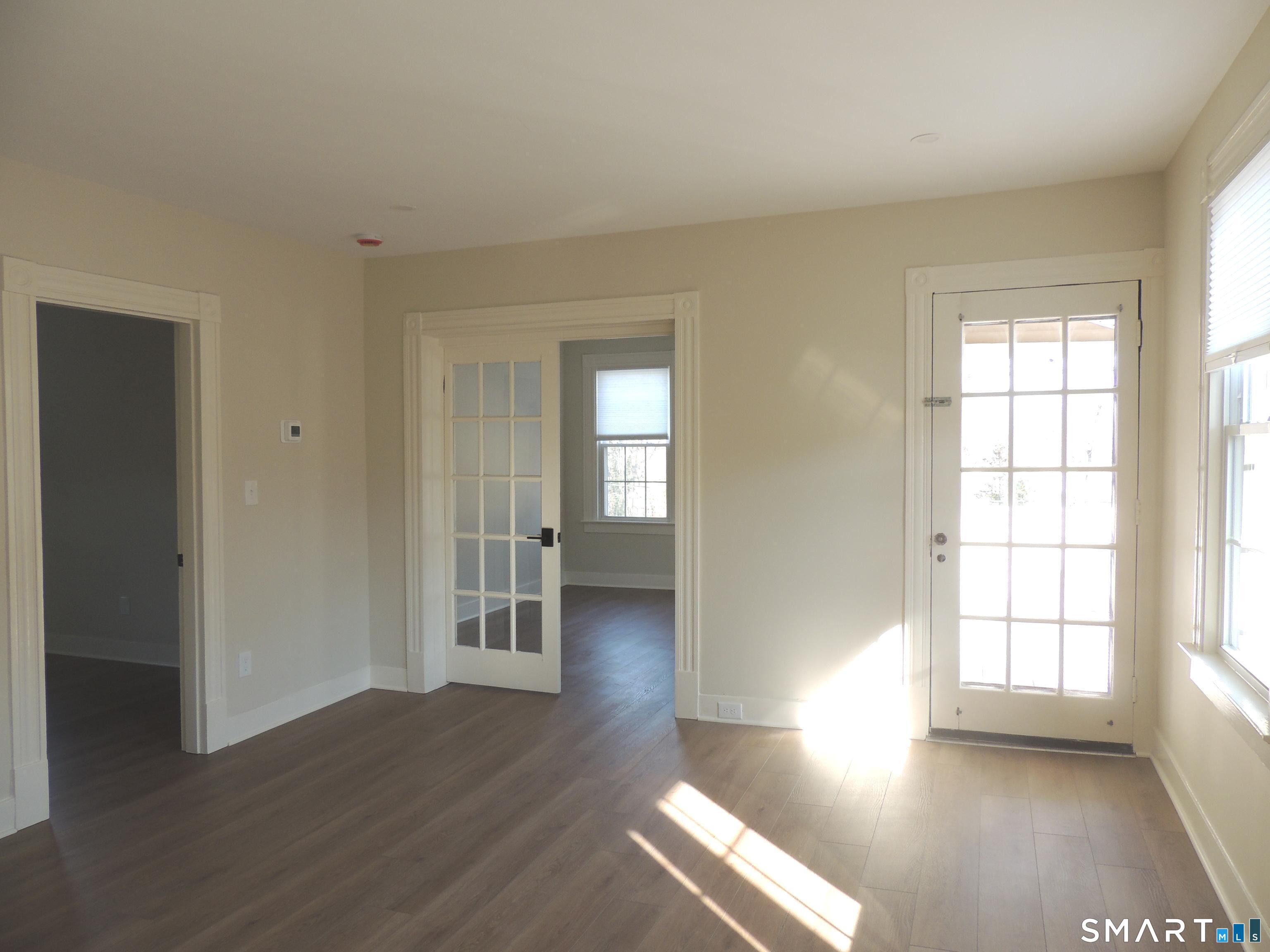 56-58 Harrison Avenue, Unit 2 Branford, CT 06405 - Photo 12 of 39 an empty room with wooden floor and windows