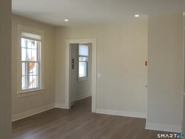 a view of an empty room with wooden floor