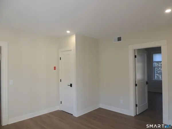 a view of an empty room with wooden floor