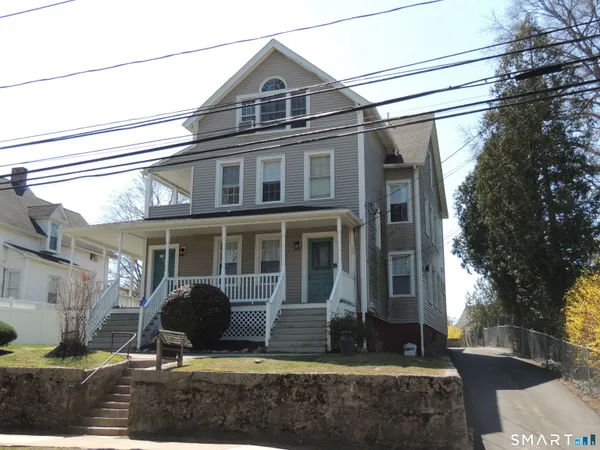 a view of a white house with large windows and a yard