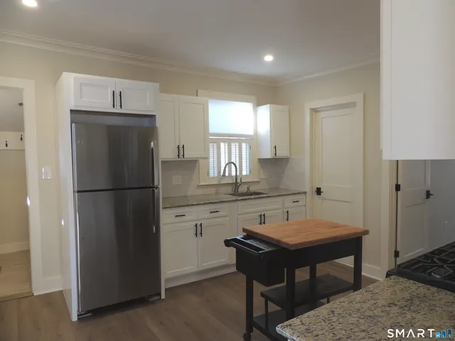 a kitchen with kitchen island a dining table chairs and a stove