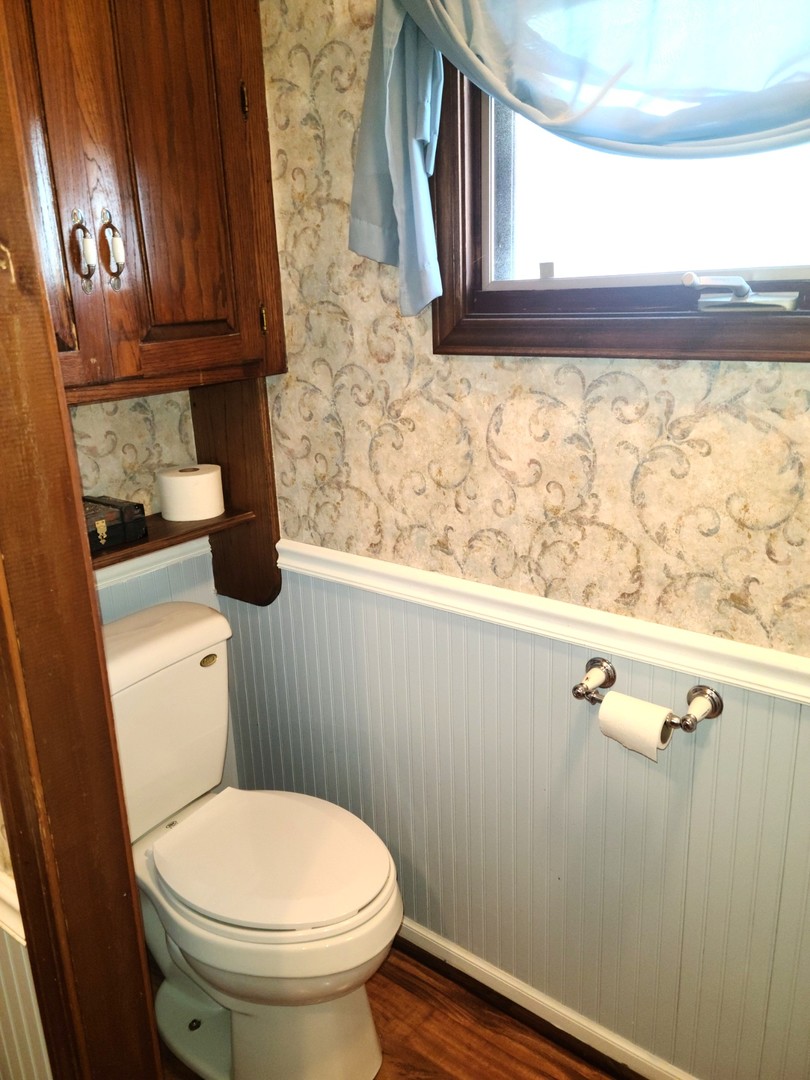 6801 South La Grange Road Hodgkins, IL 60525 - Photo 14 of 26 a bathroom with a toilet a sink and a window