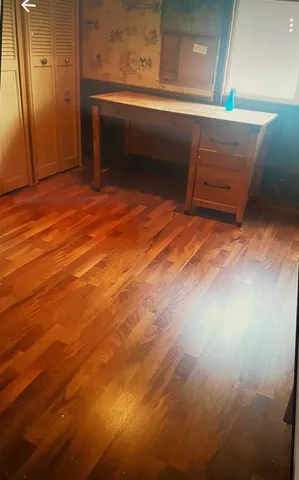 a room with wooden floor and windows