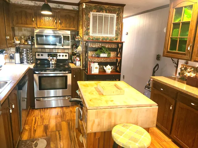 a kitchen with stainless steel appliances kitchen island granite countertop a stove and a sink