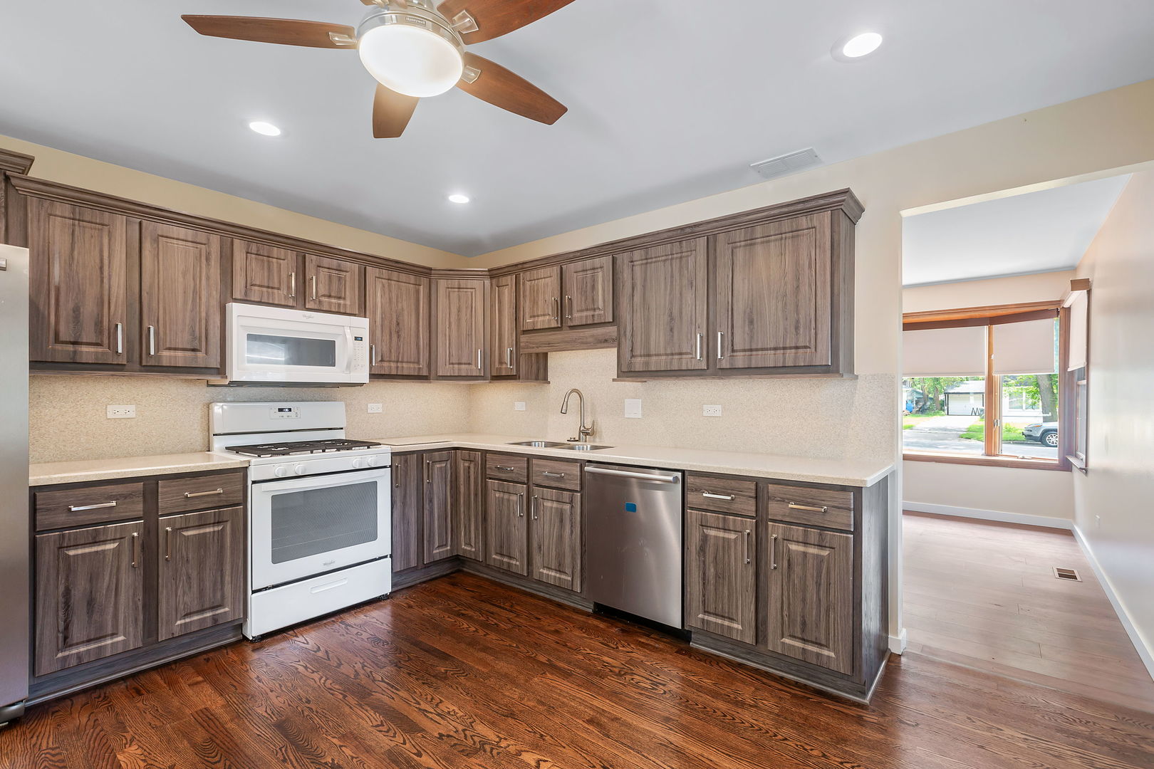 2404 George Street Rolling Meadows, IL 60008 - Photo 7 of 27 a kitchen with stainless steel appliances granite countertop wooden cabinets a sink a stove a refrigerator and island with wooden floors