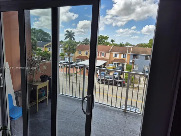 a view of a balcony with a floor to ceiling window wooden floor and a floor to ceiling window