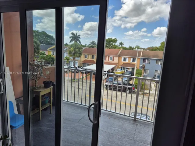 a view of a balcony with a floor to ceiling window wooden floor and a floor to ceiling window
