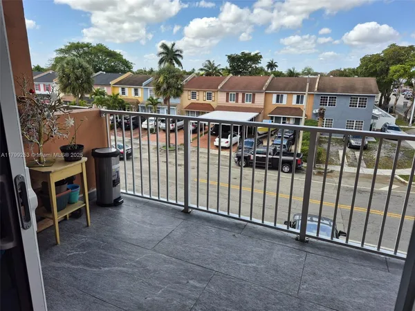 a view of a balcony with wooden floor and fence