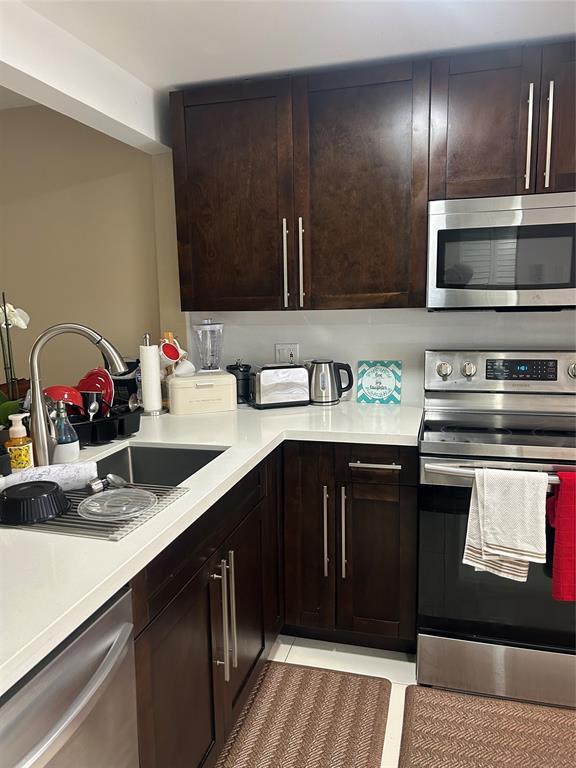 3521 Inverrary Drive, Unit J109 Lauderhill, FL 33319 - Photo 3 of 15 a kitchen with stainless steel appliances granite countertop a sink stove and cabinets