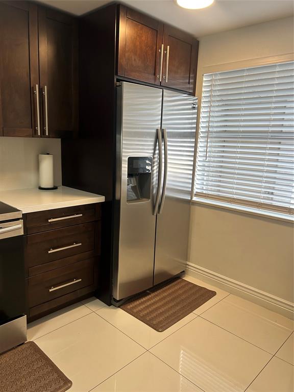 3521 Inverrary Drive, Unit J109 Lauderhill, FL 33319 - Photo 5 of 15 a kitchen with a refrigerator and cabinets