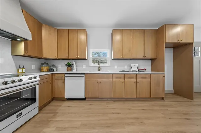 a kitchen with stainless steel appliances granite countertop a stove a sink and a refrigerator