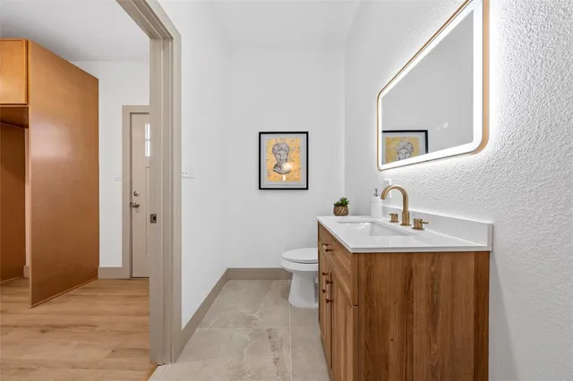 a en suite bathroom with a granite countertop sink and a mirror