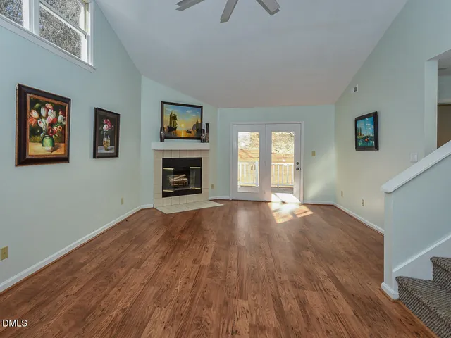 a view of empty room with wooden floor and fireplace