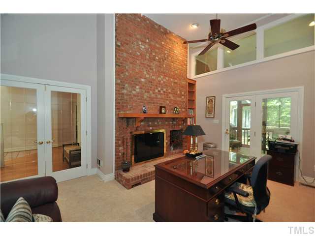 6424 Rushingbrook Drive Raleigh, NC 27612 - Photo 3 of 25 a living room with furniture a fireplace and a flat screen tv
