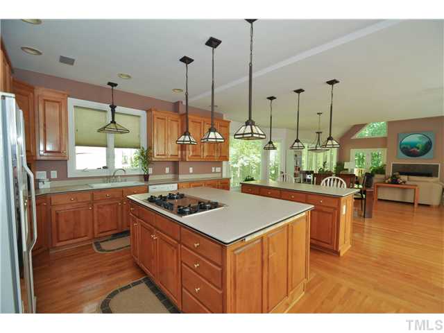 6424 Rushingbrook Drive Raleigh, NC 27612 - Photo 4 of 25 a kitchen with a stove a sink a counter top space and living room view