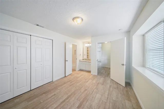 a view of a big room with wooden floor and windows