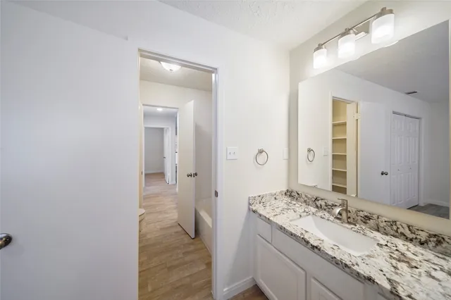 a bathroom with a granite countertop sink and a mirror
