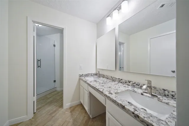 a bathroom with a granite countertop sink and a mirror