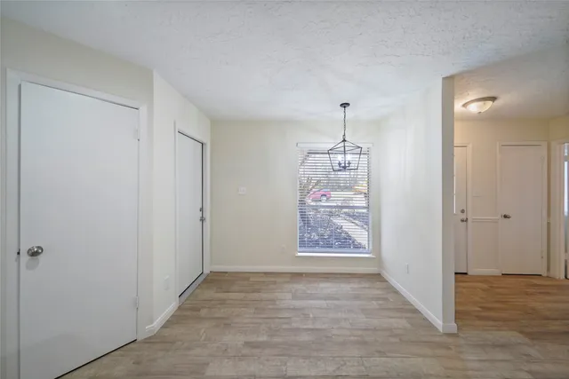 a view of a hallway with wooden floor and a window