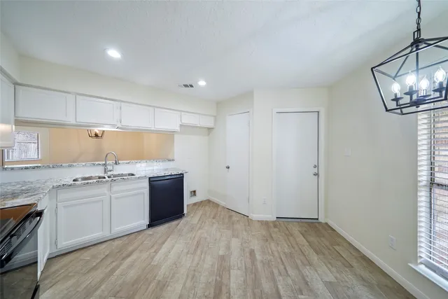 a kitchen with a sink dishwasher a stove and a refrigerator with wooden floor